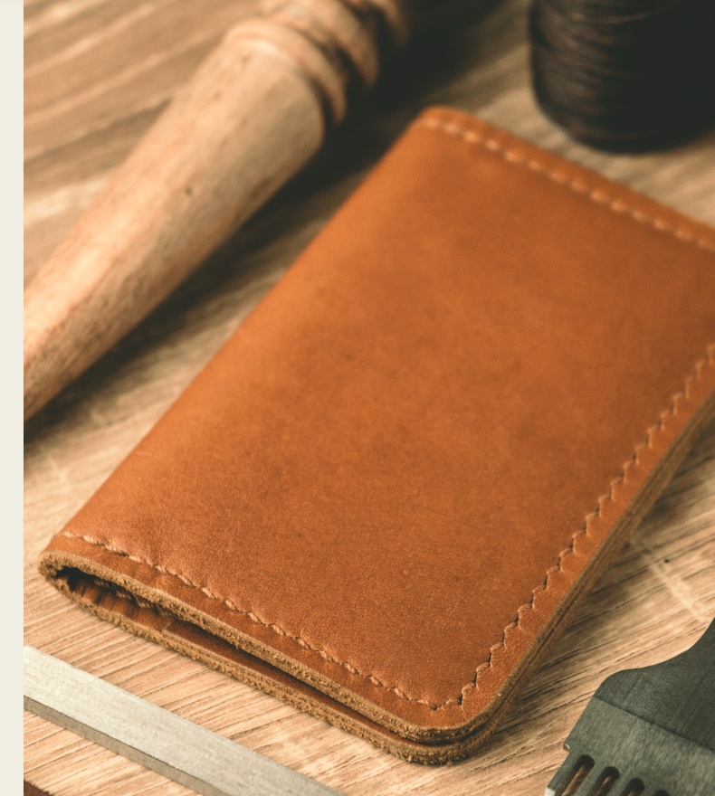 Leather restoration workbench with handcrafted wallet and tools